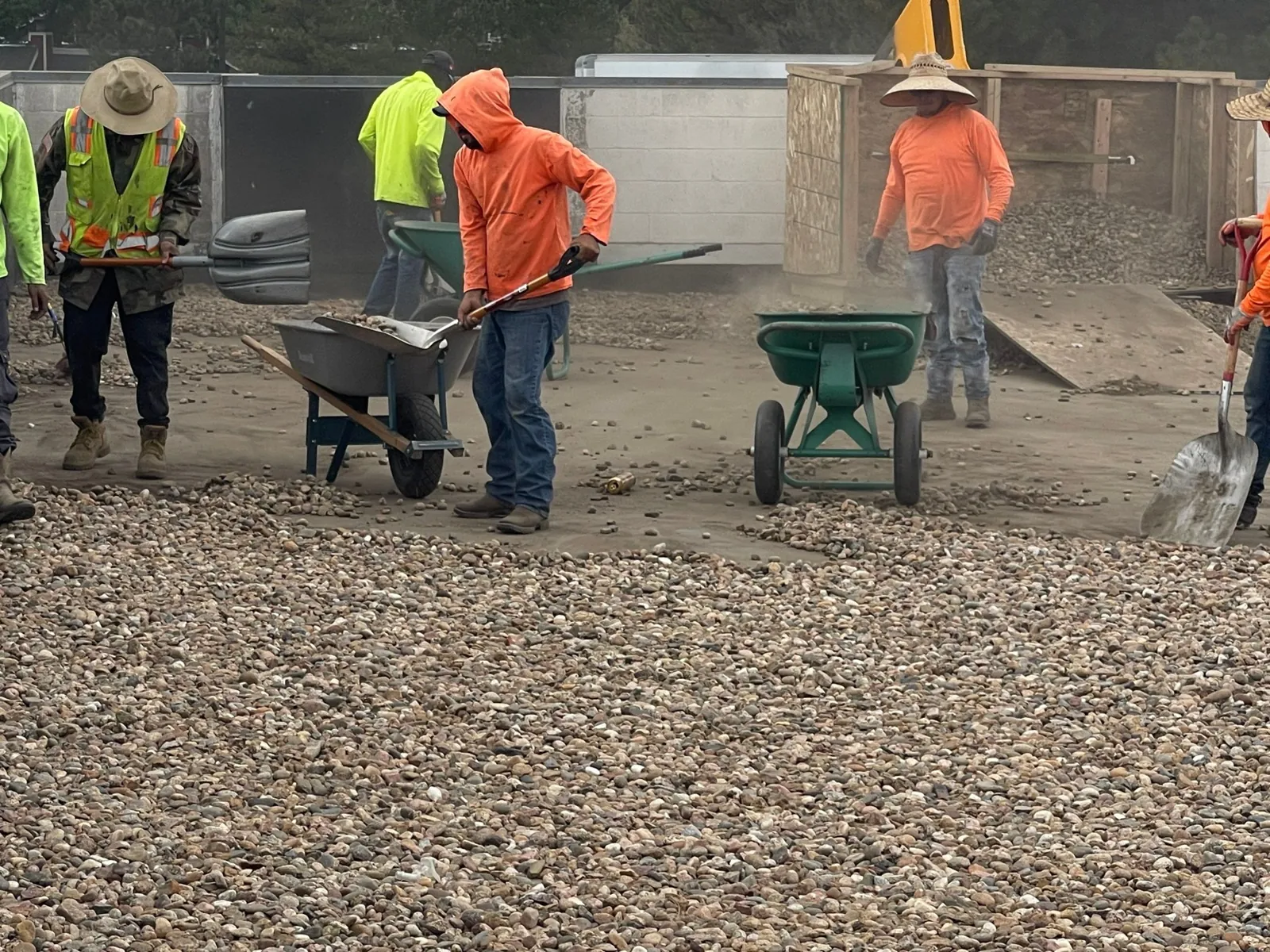 Crews removing gravel ballast by wheelbarrow