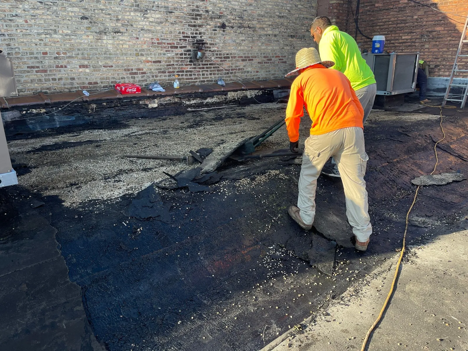 Crew removing gravel and asphalt by hand