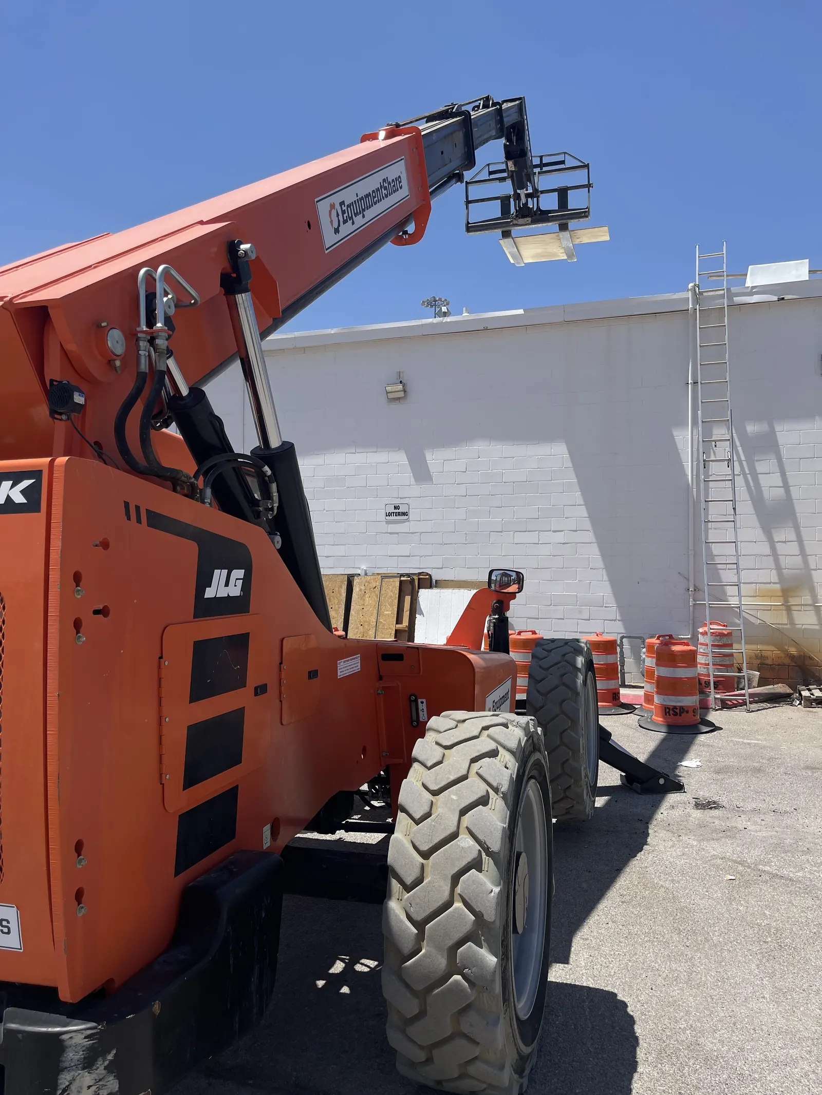 Telehandler staged to load roofing materials onto a commercial roof